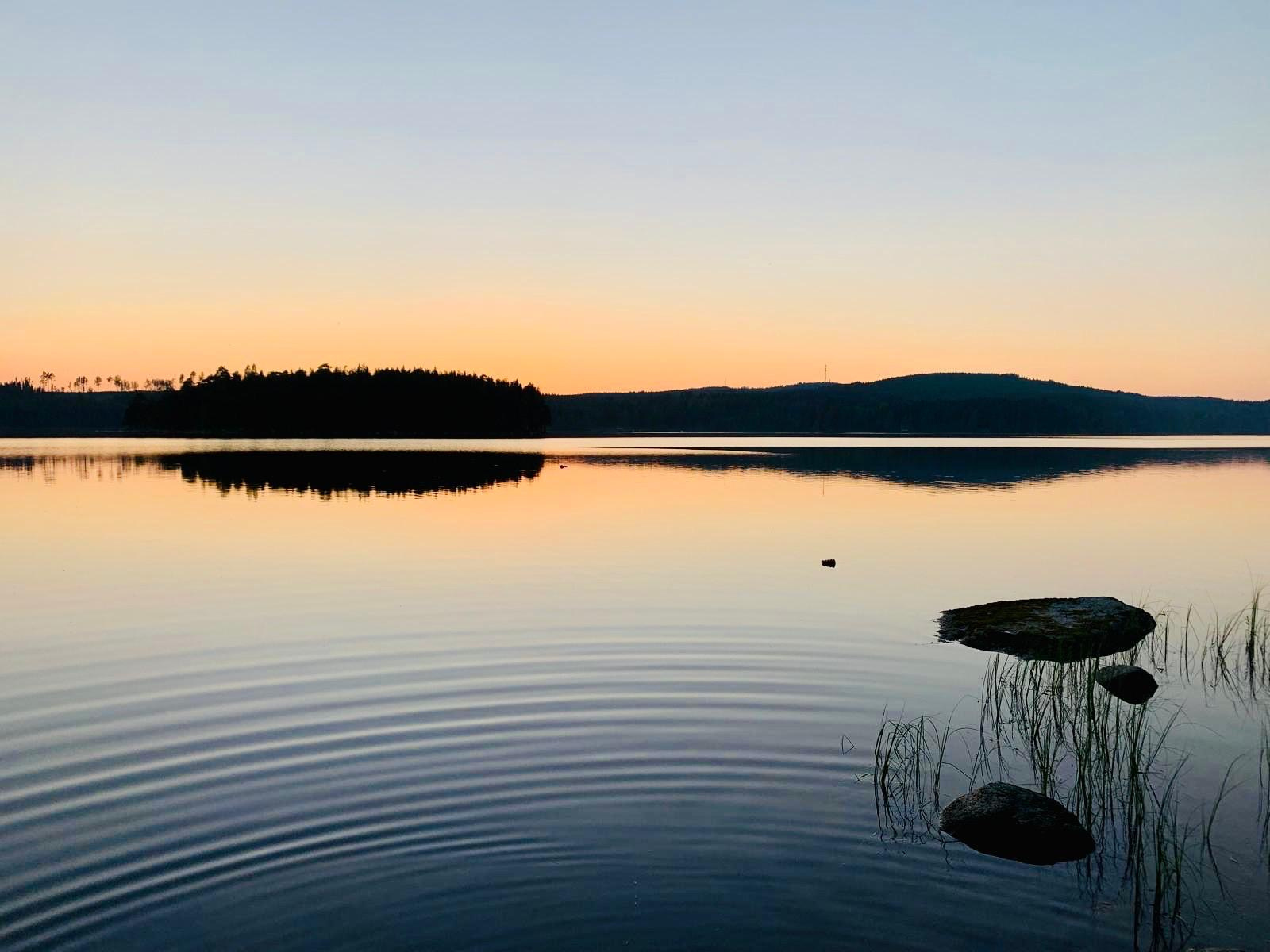 Schwedischer Waldsee im warmen Abendlicht